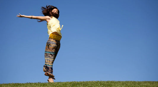 Woman jumping freely outdoors under a clear blue sky, symbolising renewed energy, vitality, and inner wellness — reflecting the benefits of exploring Methylene Blue for cellular energy support.