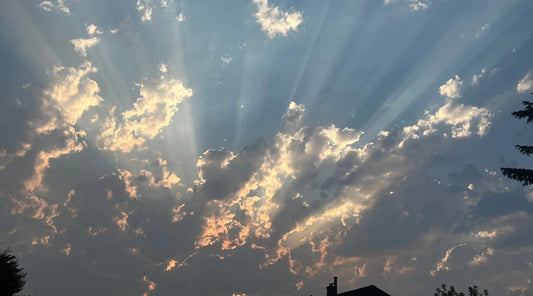 Sun rays breaking through clouds in expansive sky, symbolising clarity, renewal, emotional balance, inner calm, and gentle support for overall wellbeing journey