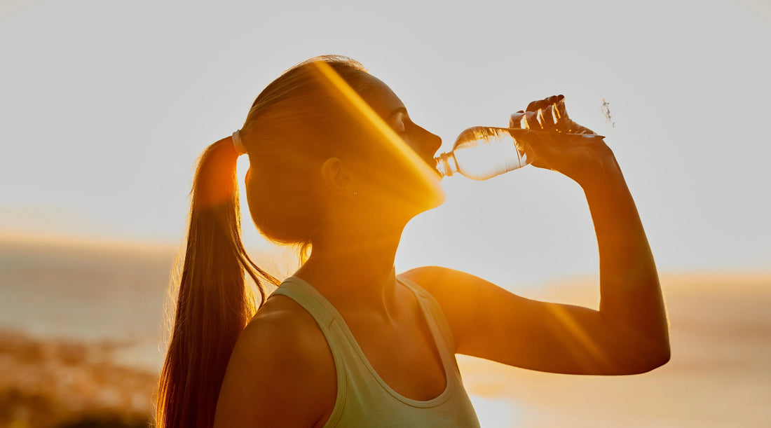 Woman drinking water outdoors in warm weather as part of healthy spring hydration habits in Australia.