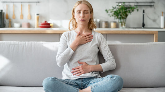 Woman practising mindful breathing at home as part of a gentle spring routine to support gut health, digestion and overall wellbeing.